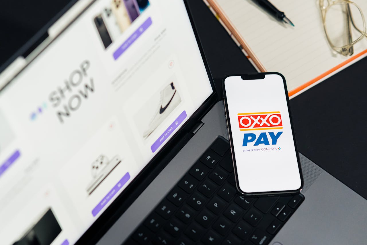hero-img-01 A mobile phone with OXXO Pay on a laptop used for online shopping.